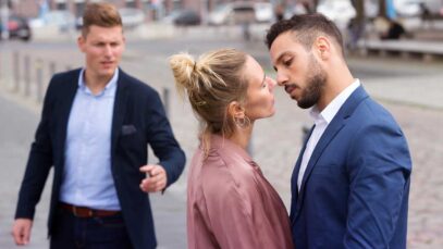 woman kissing man while another is upset